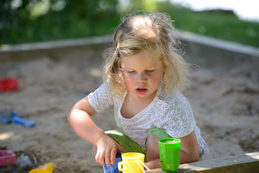girl is playing in a sandbox