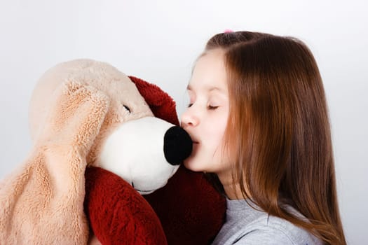 teen girl kissing a toy dog ​​in the nose