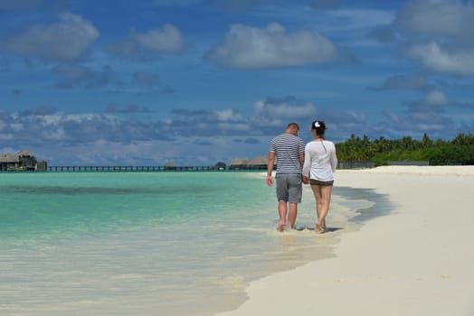 happy young couple have fun and relax at summer vacation on background maldives travel location and beautiful white sand beach
