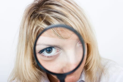 Girl is looking through a magnifying glass