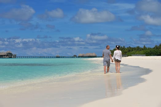 happy young couple have fun and relax at summer vacation on background maldives travel location and beautiful white sand beach