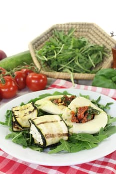 Zucchini rolls and stuffed mozzarella on a bed of rocket