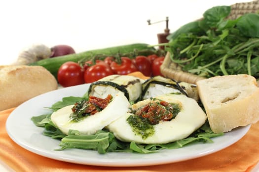 Zucchini rolls and stuffed mozzarella on a bed of rocket