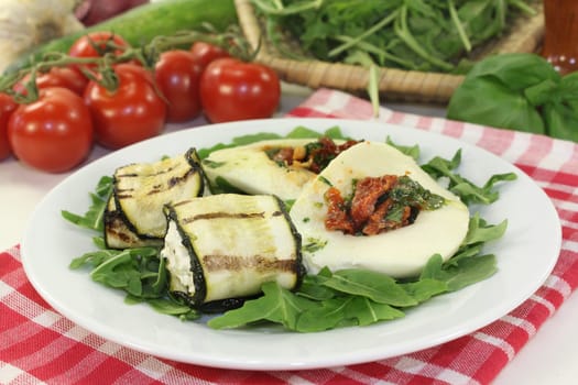 Zucchini rolls and stuffed mozzarella on a bed of rocket