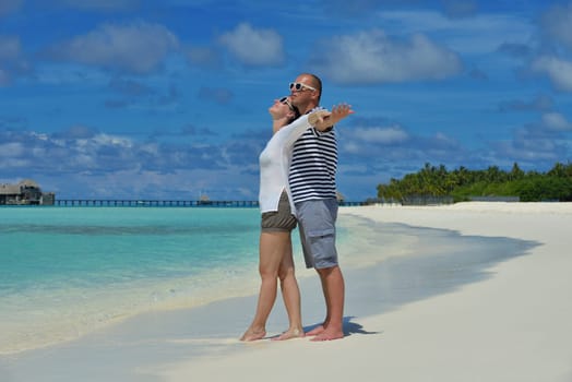 happy young couple have fun and relax at summer vacation on background maldives travel location and beautiful white sand beach