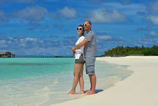 happy young couple have fun and relax at summer vacation on background maldives travel location and beautiful white sand beach