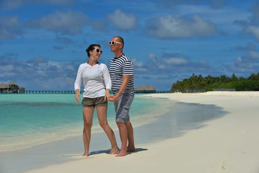 happy young couple have fun and relax at summer vacation on background maldives travel location and beautiful white sand beach