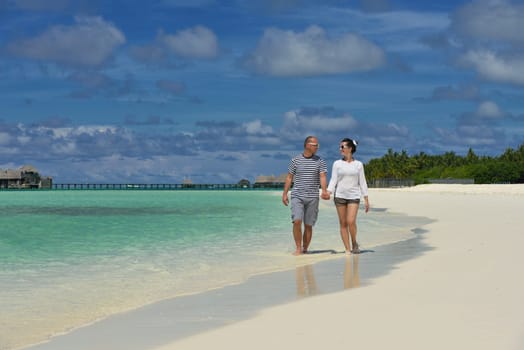 happy young couple have fun and relax at summer vacation on background maldives travel location and beautiful white sand beach
