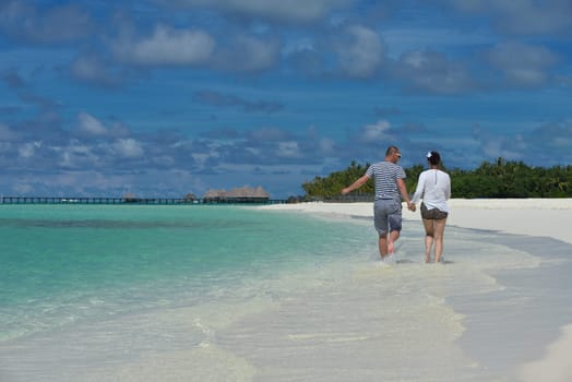 happy young couple have fun and relax at summer vacation on background maldives travel location and beautiful white sand beach