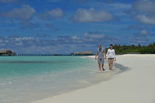 happy young couple have fun and relax at summer vacation on background maldives travel location and beautiful white sand beach