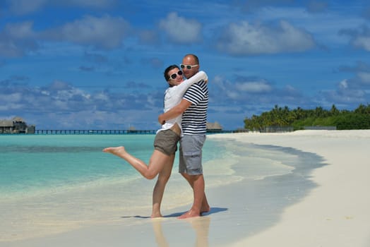 happy young couple have fun and relax at summer vacation on background maldives travel location and beautiful white sand beach