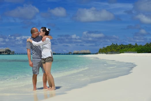 happy young couple have fun and relax at summer vacation on background maldives travel location and beautiful white sand beach