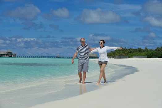 happy young couple have fun and relax at summer vacation on background maldives travel location and beautiful white sand beach