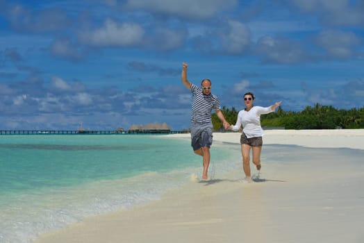 happy young couple have fun and relax at summer vacation on background maldives travel location and beautiful white sand beach