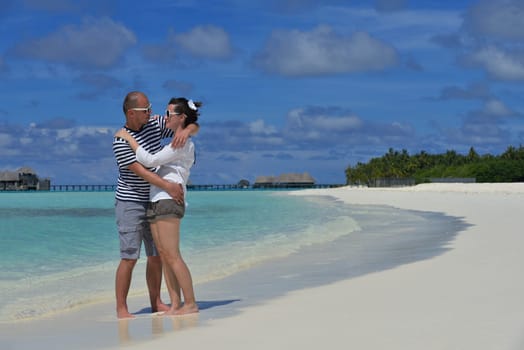 happy young couple have fun and relax at summer vacation on background maldives travel location and beautiful white sand beach