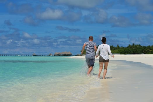 happy young couple have fun and relax at summer vacation on background maldives travel location and beautiful white sand beach
