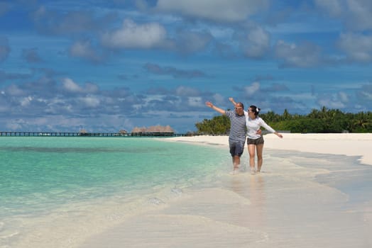 happy young couple have fun and relax at summer vacation on background maldives travel location and beautiful white sand beach