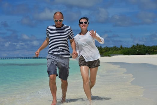 happy young couple have fun and relax at summer vacation on background maldives travel location and beautiful white sand beach