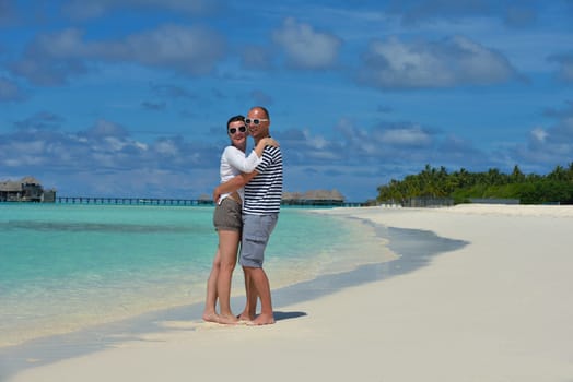 happy young couple have fun and relax at summer vacation on background maldives travel location and beautiful white sand beach