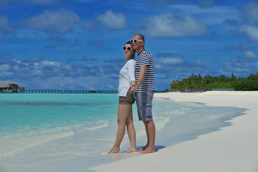 happy young couple have fun and relax at summer vacation on background maldives travel location and beautiful white sand beach