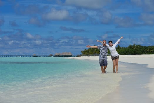 happy young couple have fun and relax at summer vacation on background maldives travel location and beautiful white sand beach