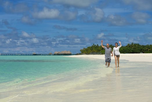 happy young couple have fun and relax at summer vacation on background maldives travel location and beautiful white sand beach