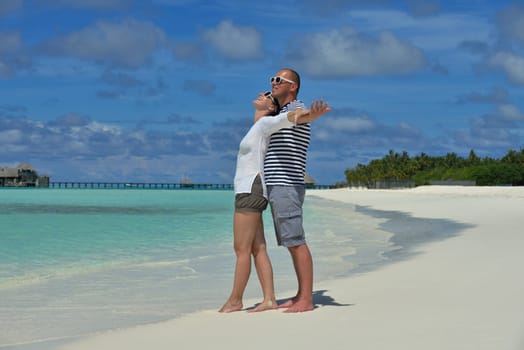 happy young couple have fun and relax at summer vacation on background maldives travel location and beautiful white sand beach