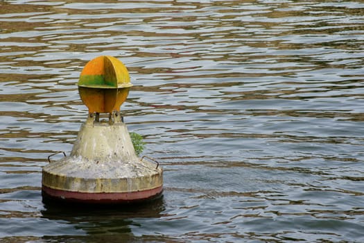 The photograph of a buoy on a strikingly undulating water surface.