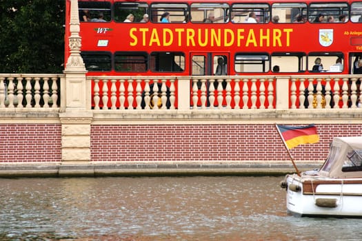 Schwerin,Germany – August 11,2013: A red double-decker bus with holidaymakers makes a city tour along the Schwerin Castle Island on August 11,2013 in Schwerin.