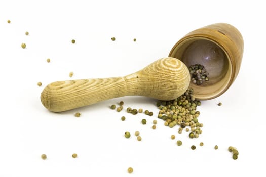 Peppercorns in and in front of a lying mortar