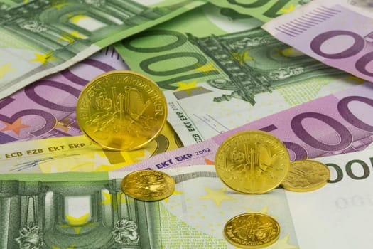 various gold coins on euro banknotes