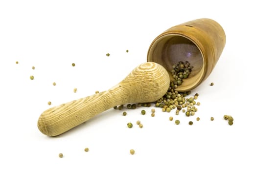 Peppercorns in and in front of a lying mortar