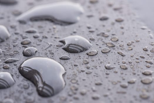 Natural raindrops pattern on wooden table extreme close-up