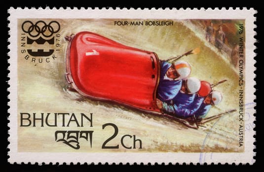 BHUTAN - CIRCA 1976: A stamp printed in Bhutan shows four man bobsleigh at the Olympic Winter Games in Innsbruck, circa 1976