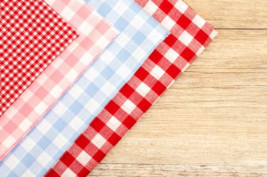 Checkered fabrics and wooden table with text space