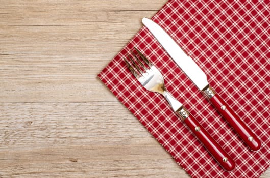 Knife and fork in red with checkered napkin