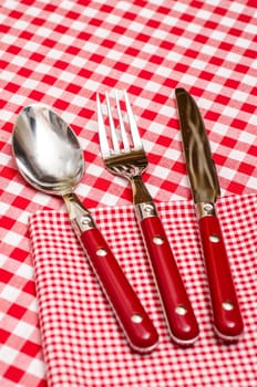 Red cutlery in the restaurant on a napkin with checks
