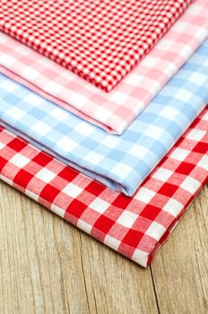 Stacks of fabrics with checks in portrait format on a wooden board
