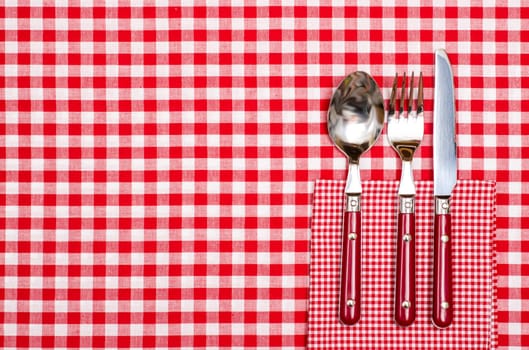Table in restaurant with spoon,fork and knife in red