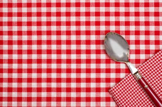Tablecloth with red and white checks and napkin with spoon