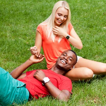 Young in love multicultural couple on a meadow in summer leisure fun