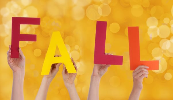 Many Person Holding the Word Fall whit a Yellow Background
