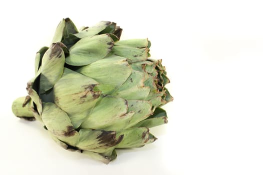 fresh,raw artichokes against a white background