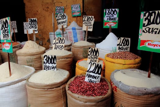 Bags of Rice Beans and Sugar, with prices, in a market in Kampala, Uganda
