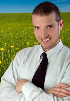 smiling businessman standing in the green outdoors