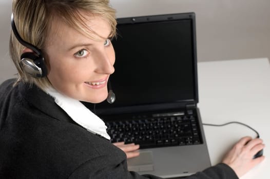 woman with headset working on laptop close up