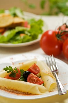 Appetizer with cheese, tomatoes and black olives