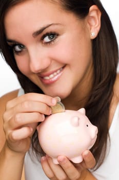 young brunette girl holding piggy bank close up