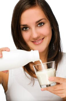 young brunette woman pouring milk into glass close up