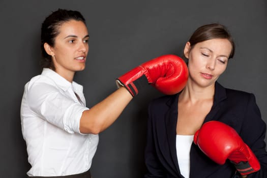 Two businesswomen with red boxing gloves